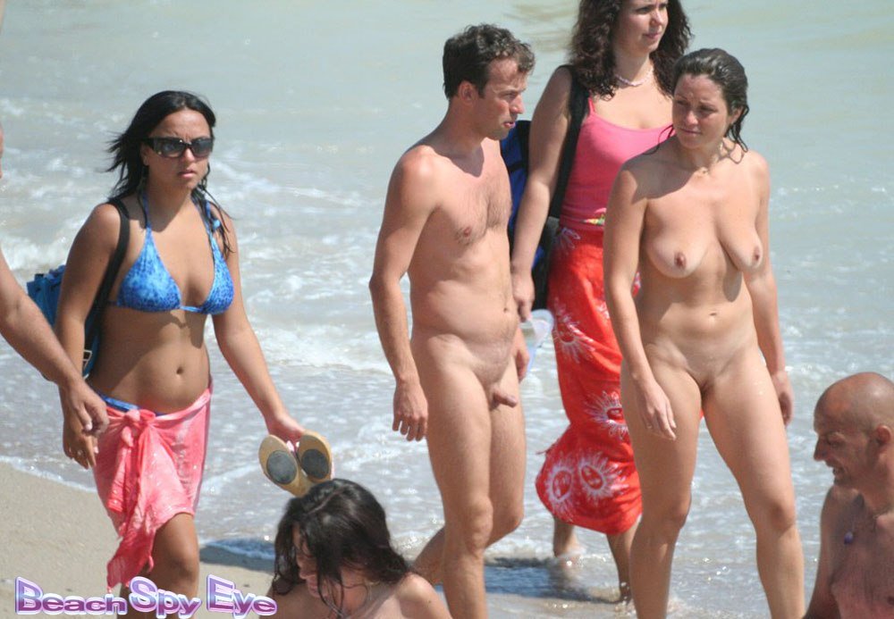 Nudists companies and pair naked on the beach.
